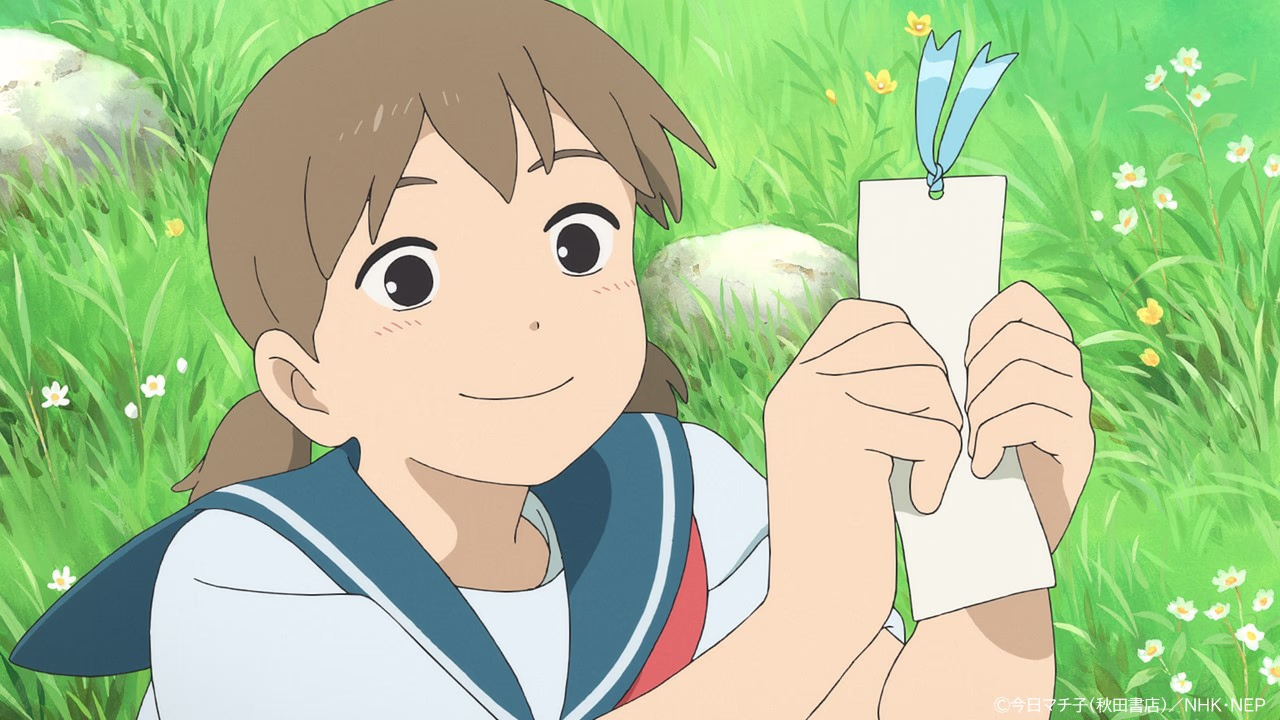 Mayu smiling in the grass while holding up a white bookmark tied with a blue ribbon.